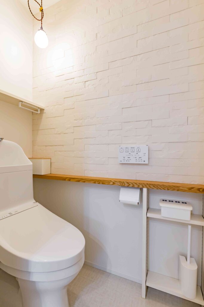 豊橋市でリノベーションを手掛けるリノクラフト株式会社が設計施工したI様邸のトイレの事例写真です。レンガのような壁は、デザイン性もありながら調湿、気になるにおいを脱臭してくれるLIXILのエコカラット。